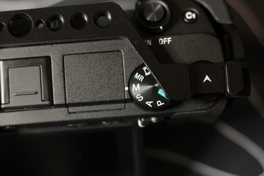 Photographer adjusting camera settings outdoors.