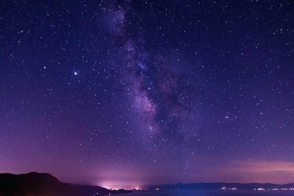 Night shot with starry sky and calm lake.